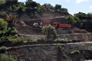 Pala, retroexcavadora y camión trabajando en la corrección de un talud