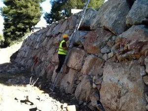 Operario con chaleco revisando un muro de escollera