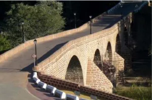 Puente histórico de arcos de ladrillo con la calzada rehabilitada